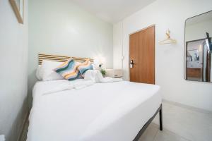 um quarto branco com uma grande cama branca em Room 3 Vibrant Walkable Hub in Santurce em San Juan