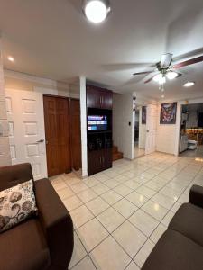 a living room with a couch and a ceiling fan at House in Alta Vista Complex in San Martín