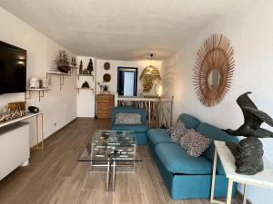 a living room with a blue couch and a table at L'Albatros in Marseille