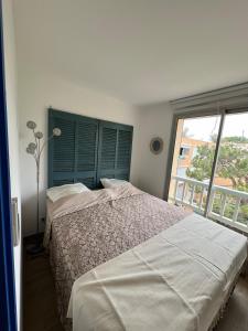 a bedroom with a bed and a large window at L'Albatros in Marseille