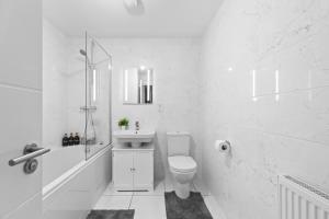 une salle de bain blanche avec toilettes et lavabo dans l'établissement Contractor & Family Friendly 4-BR House - Leads, à Cross Gates 28 autres photos