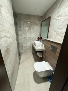 a bathroom with a toilet and a sink and a mirror at Penta Square Superior Executive Apartments-DHA Lahore in Lahore +43 photos