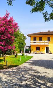a yellow house with a pink tree in front of it at YARD 151 in Noventa di Piave
