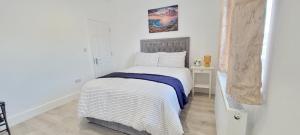 Un dormitorio con una cama con una manta azul y blanca. en Luxury 2 Bedroom Home Dagenham, en Dagenham