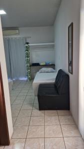 ein Schlafzimmer mit einem Bett und einer Couch in einem Zimmer in der Unterkunft Pousada Martanha in Porto Belo
