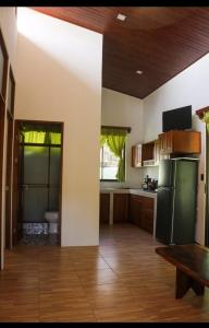 a large kitchen with a refrigerator and a table at Casa Jicaro in Nosara