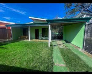 a green house with a fence in a yard at Casa Jicaro in Nosara +9 photos
