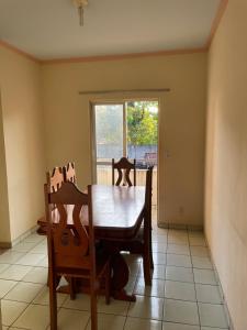 a dining room with a table and chairs and a window at Ap COP 30 in Ananindeua