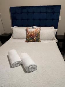 Una cama con toallas y una cabecera azul. en Al-Pat, en Vosburg