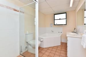 a bathroom with a toilet and a sink and a shower at Palm Beach 33B Shoal Bay Road in Shoal Bay +2 photos