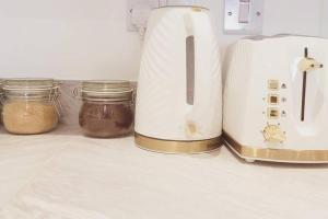 a toaster and two jars on a kitchen counter at Lakeside Apartment - 2 Bed, Free Parking in West Thurrock +9 photos