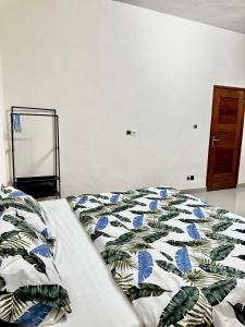 Una cama con un edredón y almohadas encima en Simple Ecomomy Room in Cotonou, en Mama 10 fotos más