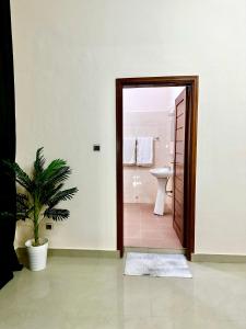 Un baño con inodoro y una puerta con una planta. en Simple Ecomomy Room in Cotonou, en Mama
