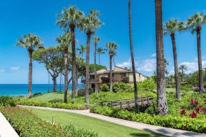 a house on a golf course with palm trees and the ocean at Wailea Elua 808 - Scenic Ocean Views, Classic Wailea Charm, Central AC, Wi-Fi in Wailea