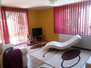 a living room with a white bench in front of windows at Casa Brad Sovata in Sovata