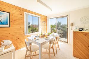a kitchen and dining room with a white table and chairs at The Verandah fantastic child friendly home in Anna Bay
