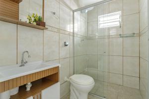 a bathroom with a toilet and a shower and a sink at CUSTO X BENEFÍCIO COM CONFORTO -AR COND-wifi in Florianópolis
