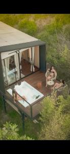 dos personas sentadas en una bañera de hidromasaje en una terraza en Cabañas para parejas cerca a Medellín - LUUM By Roots Rentals, en Marinilla