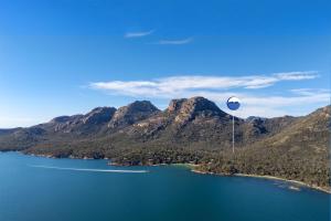 a person in a parachute flying over a lake at Hazards Rim in Coles Bay