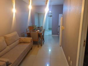 a living room with a couch and a table and a kitchen at Cantinho das Orquídeas! in Pelotas