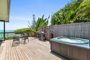 a hot tub on a deck with a table and chairs at G SPOT UPPER LEVEL with spa in Raglan +18 photos