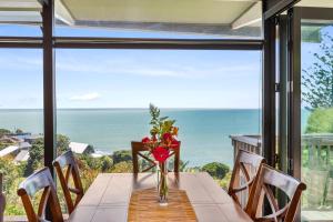 a table with a vase of flowers sitting on top of a window at G SPOT UPPER LEVEL with spa in Raglan