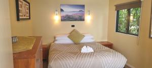 a small bedroom with a bed and a desk at G SPOT UPPER LEVEL with spa in Raglan