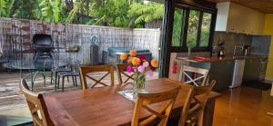 a kitchen and dining room with a table with flowers on it at G SPOT UPPER LEVEL with spa in Raglan