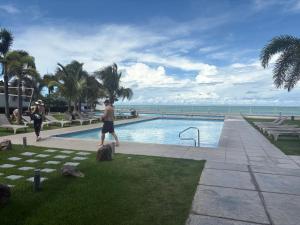 a man standing next to a swimming pool next to the ocean at Gorgona playa in Nueva Gorgona