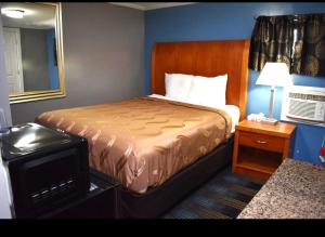 a hotel room with a bed and a nightstand with a bed sidx sidx sidx at Pilgrim Inn & Cottages in Plymouth