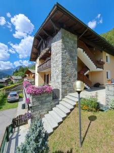 una casa con una escalera de piedra delante de ella en Appartamento Panorama Bormio, en Bormio