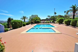 una piscina en un patio con árboles y arbustos en Beate - holiday bungalow with pool in Moraira, en Moraira