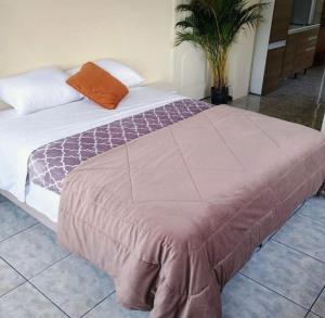 a bedroom with a large bed with an orange pillow at centrico departamento in Cusco
