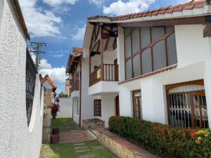 a row of houses with flowers in a yard at Refugio de Paz Casa en Anapoima in Anapoima