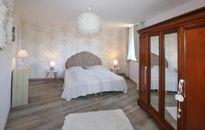una camera da letto con un letto, due lampade e uno specchio di Demeure Romantique Le Pêcher a Pont-de-Labeaume