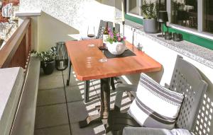 una mesa de madera en un balcón con 2 sillas en Haus Lindorfer-Ferienwohnung, en Grossarl