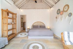 een slaapkamer met een bed en een bank in een kamer bij Villa Satu Cinta in Gili Air +37 foto's