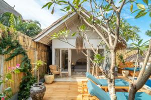 een terras met blauwe stoelen en een boom bij Villa Satu Cinta in Gili Air