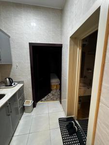 a bathroom with a door leading into a bathroom with a sink at شقق فايا in Jazan
