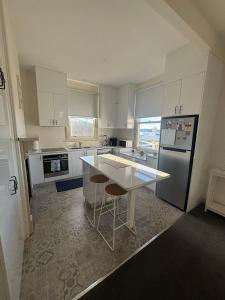 une cuisine avec des placards blancs et un comptoir blanc dans l'établissement West Hobart 3 Bed Cottage with river and city views, à West Hobart