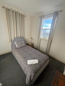 - une chambre avec un lit doté d'un couvre-lit à motifs léopards et une fenêtre dans l'établissement West Hobart 3 Bed Cottage with river and city views, à West Hobart