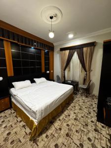 a bedroom with a large white bed and a chair at شقق فايا in Jazan