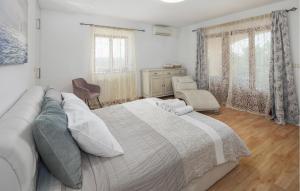 a bedroom with a large bed and a couch at Lovely Home In Tinjan in Tinjan