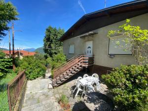 a house with a white table and a wooden ramp at Villa la Palma in Gemonio