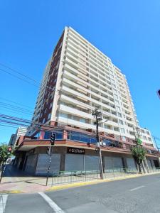 a large white building on the corner of a street at Arriendo 1 Departamento Diario Amoblado en Edificio Pleno Centro de Osorno Full Eléctrico y Estacionamiento Techado, Comodidad, Moderno y Seguridad in Osorno