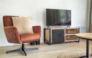 a living room with a chair and a tv at 2 Bedroom Lovely Home In Hellendoorn in Hellendoorn