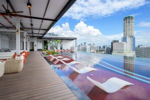 a rooftop patio with white chairs and a view of the city at Fifth Avenue Hotel in George Town