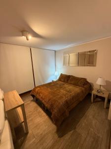 Un dormitorio con una cama grande y una mesa. en Costanera Suites Los Leones, en Santiago