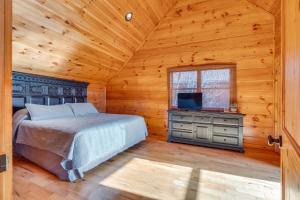 a bedroom in a log cabin with a bed and a television at Majestic Manor - Peaceful Modern Cabin Retreat Near Watauga Lake in Butler