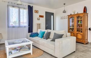 a living room with a white couch and a table at Maison Proche Mer in Saint-Valéry-en-Caux